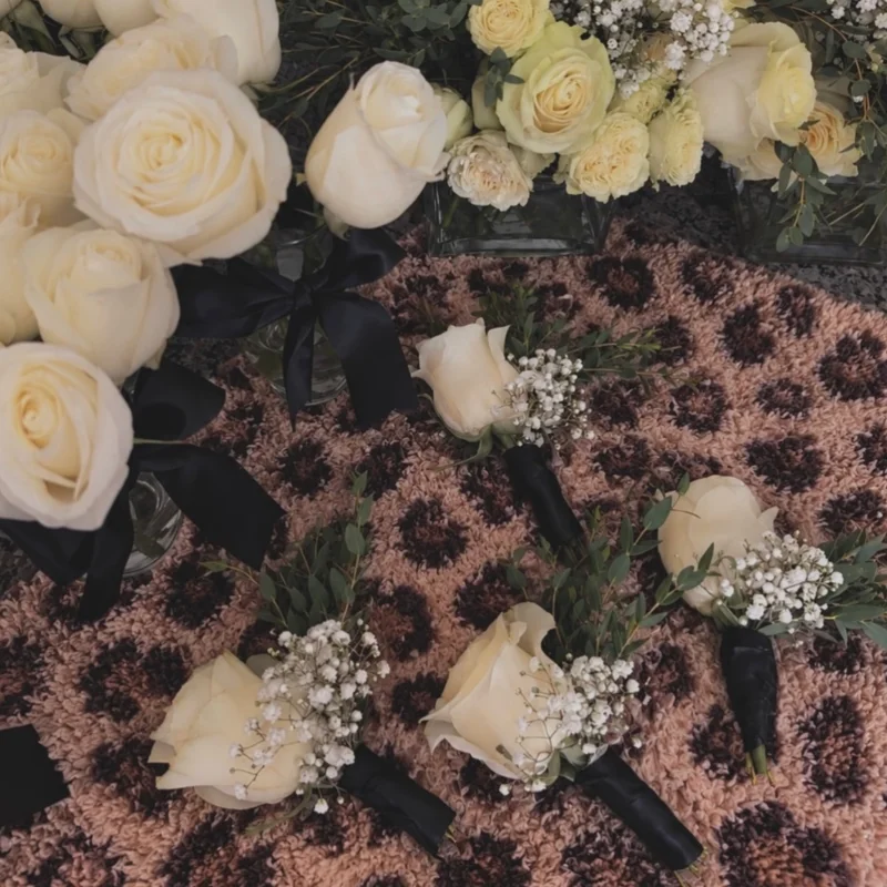 White rose wedding details and small floral pieces arranged on animal-print fabric
