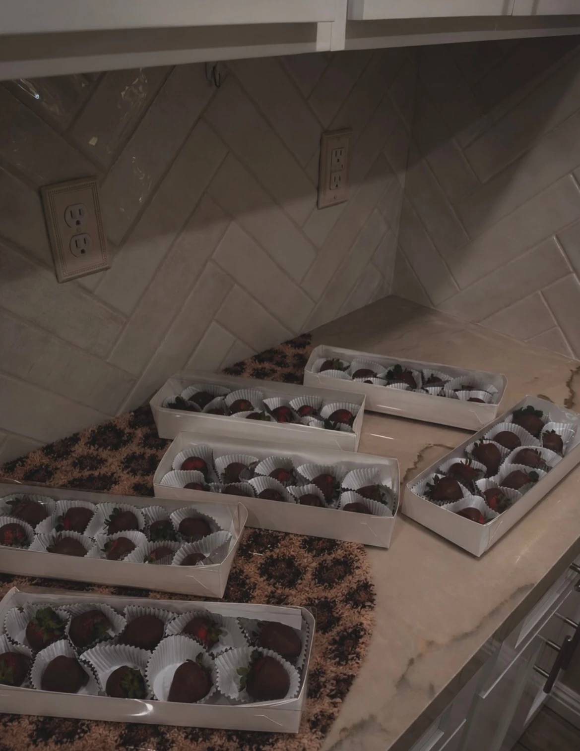 Dozen boxes of chocolate covered strawberries on an animal print runner