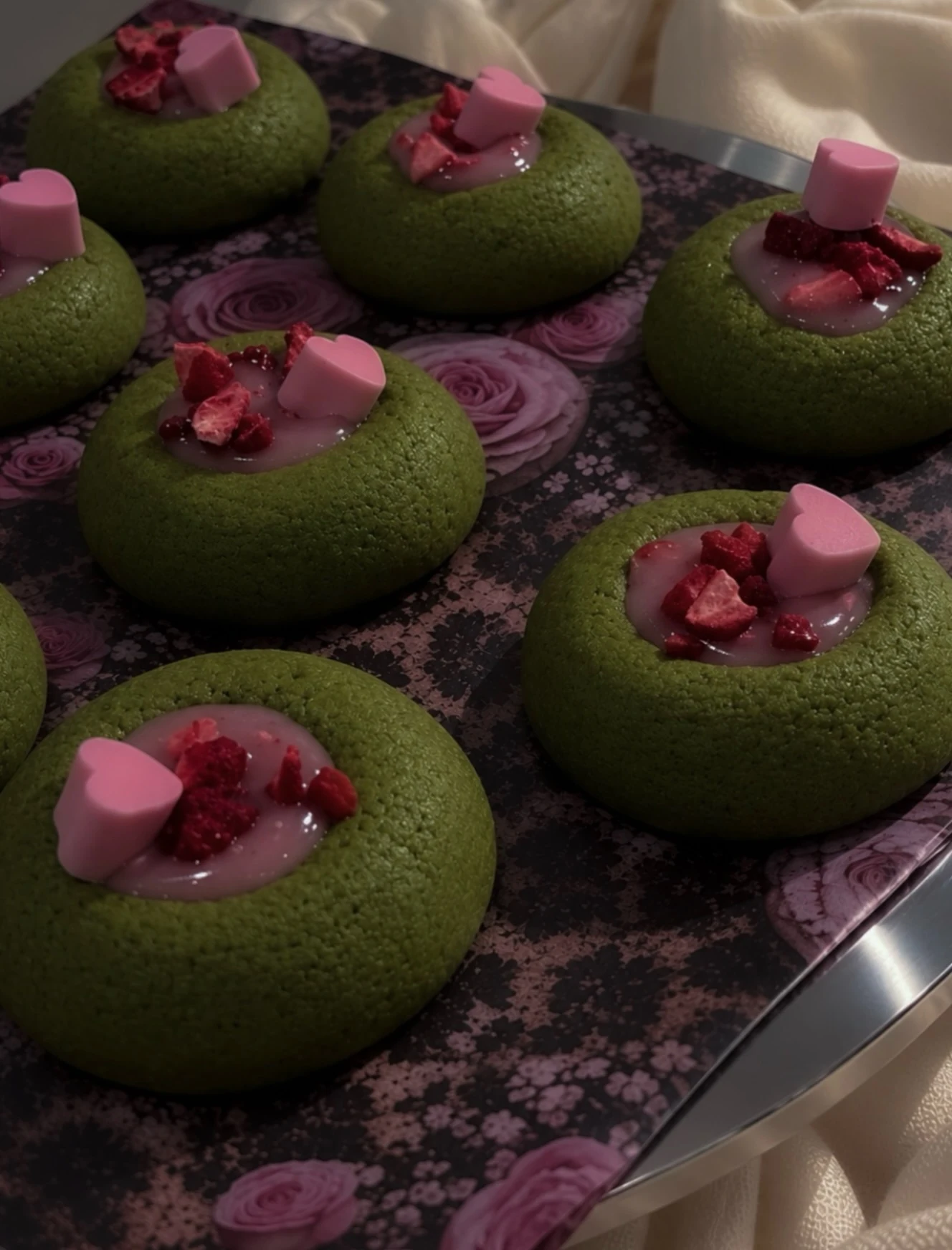 Green matcha cookies with pink heart decorations and strawberries